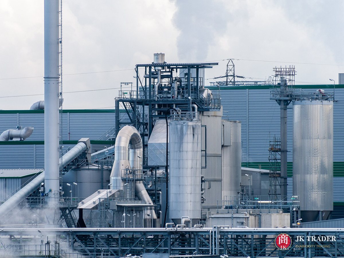 Planta industrial con torres de acero, tuberías y vapor